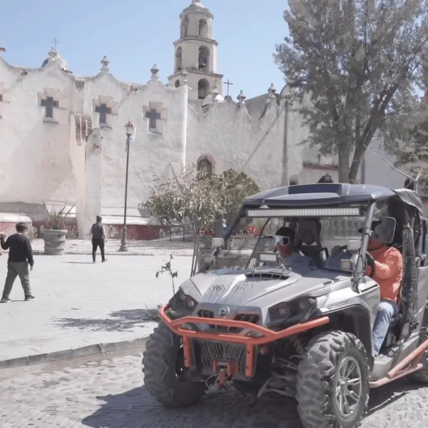 Guey Tours: Atotonilco Sightseeing on UTV & ATV Tours A gray Can-Am UTV, part of the Guey Tours ATV Tours fleet, parked in front of the historic Atotonilco church.